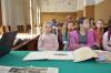 Dzieci siedzą na krzesłach w sali konferencyjnej i słuchają prelekcji na temat zasobu wrocławskiego Archiwum.