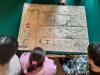 Dzieci przyglądają się mapie na zielonym stole