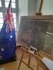 Fotgrafia pomieszczenia z wystawą w bolesławieckim Archiwum. Po lewej flaga Australii, po prawej stelaż z mapą Australii. Z tyłu okno.